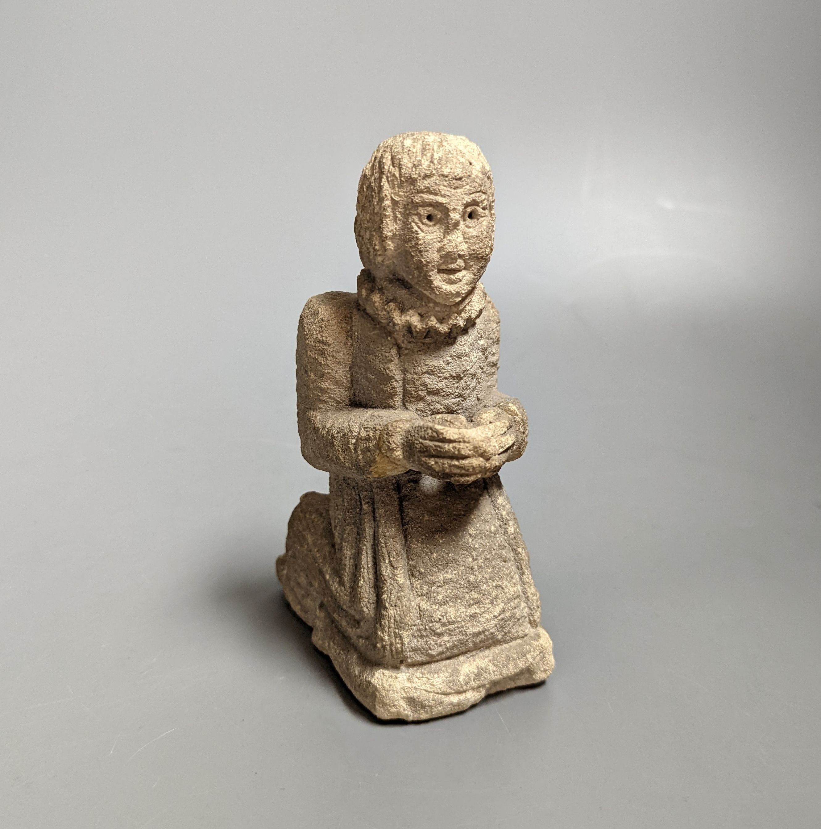 A small carved limestone kneeling/praying chorister, possibly Medieval, 13.5 cms high